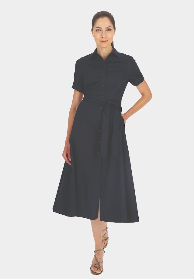 Granatowa sukienka koszulowa z dopasowanym pasem i paskiem, krótkimi rękawami, rozkloszowanym dołem i subtelnym połyskiem. Połączona z sandałami na paski.
