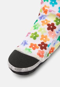 Scarpa in tessuto con motivo floreale colorato, suola in gomma nera e cuciture bianche. Presenta una parte superiore morbida e flessibile e una punta rinforzata.