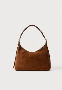 Sac à main en daim marron avec une forme incurvée, une bandoulière sombre tressée et des accents de quincaillerie dorée. Présente un design simple et épuré.