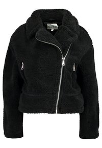 Musta shearling-takki, jossa on vetoketjukiinnitys edessä, kaksi vetoketjullista taskua ja kauluksellinen kaula. Sisältää muotoilultaan lyhyemmän designin ja tekstuuriominaisuudet.