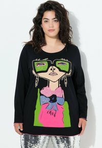 Czarna koszula z długim rękawem z kolorową grafiką przedstawiającą kobietę w zielonych okularach, różowej kokardzie i błyszczących akcentach.