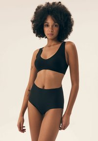 Black bralette and high-waisted underwear set, made from soft fabric, featuring a seamless design and wide straps for comfort.