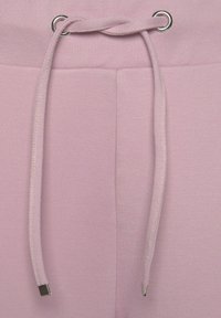 Helle rosa Sweatpants aus weichem Material, mit einem Kordelzug aus silberfarbenem Metall und zwei vorderen Taschen mit genähten Details.