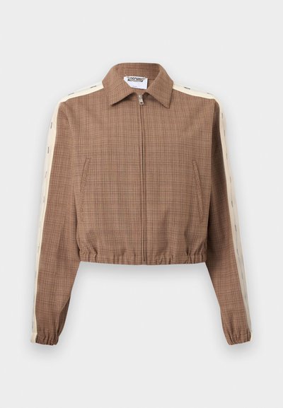 Καφέ κοντό μπουφάν με φερμουάρ, κρεμ ρίγες και μικρό κείμενο κατά μήκος των μανικιών, ελαστικές μανσέτες και στρίφωμα, και γιακάς.