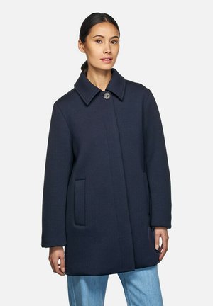 Manteau en mélange de laine bleu marine avec une fermeture à boutons, un grand col et des poches latérales. Coupe droite avec des manches longues et une texture subtile.