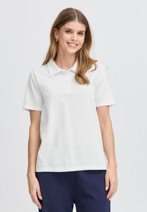 Polo bianco con colletto, maniche corte e patta con cinque bottoni. Tessuto morbido con orlo dritto. Indossato con pantaloni blu navy.