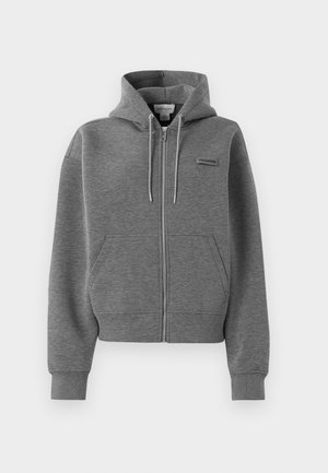 Grijze zip-up hoodie met voorzakken, trekkoordkap en klein Calvin Klein-logo op de borst tegen een witte achtergrond.