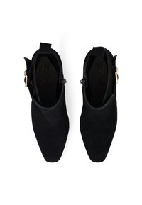 Botas de tobillo de ante negro con puntera puntiaguda y detalle de hebilla lateral. El interior es suave y tiene una suela plana.