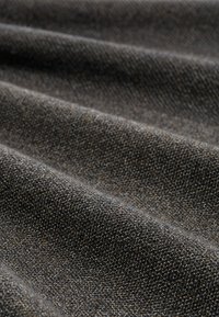 Textiel met textuur in tinten van donkergrijs en bruin, met een dicht geweven ontwerp waarin zichtbare draden en subtiele kleurvariaties te zien zijn.