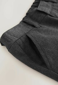 Donkere grijze stoffen shorts met een gestructureerde afwerking, zijzakken en geplooide details langs de tailleband voor een extra ontwerp.