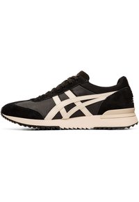 Black athletic shoes with a mesh and suede upper, featuring cream accents, a ridged rubber sole, and a classic lace-up design.