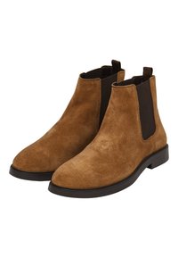 Bottines Chelsea en daim marron avec panneaux latéraux élastiques, embout arrondi lisse et semelle en caoutchouc noir. Design minimaliste pour un usage polyvalent.