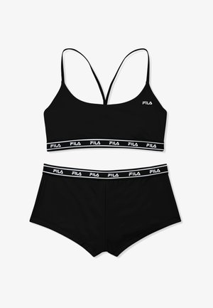 Sujetador deportivo negro de Fila con tirantes finos y bragas estilo boyshort a juego, ambos con bandas elásticas con la marca.