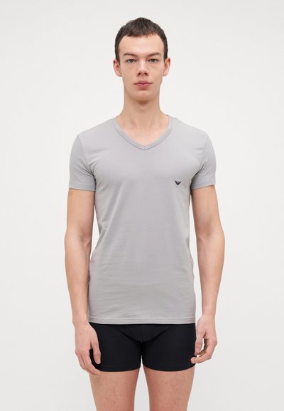 Hellgraues, kurzärmliges V-Ausschnitt-T-Shirt mit taillierter Passform und kleinem schwarzen Logo auf der linken Brust. Glatte Stoffoberfläche.