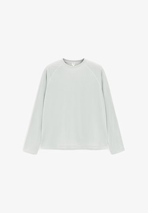 Lichtgrijs shirt met lange mouwen en een ronde halslijn met raglannaden, platliggend op een witte achtergrond.