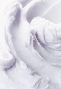 Gęsta lawendowa krem z gładką, spiralną teksturą, z drobnymi fioletowymi smugami w całej masie. Miękki połysk odbija światło.