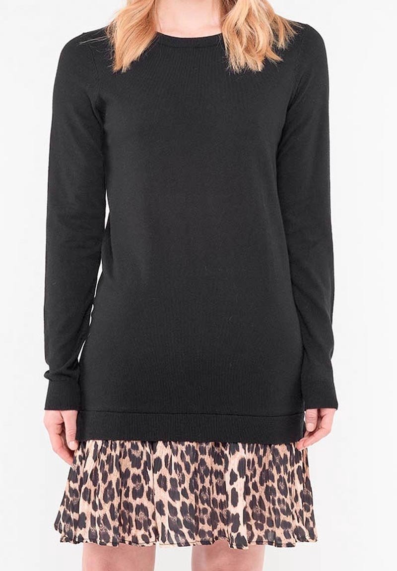 Svart långärmad topp med ribbad struktur, lager på en beige och svart leopardmönstrad kjol med volanger. Nederkanten har en ren finish.