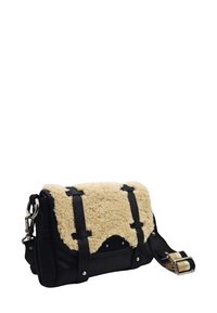 Sac crossbody en daim noir avec rabat en shearling crème, sangles à boucle noires et bandoulière en tissu rayé réglable.
