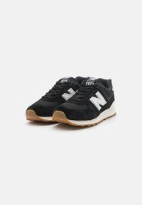 Black suede sneakers with a mesh upper, featuring a white "N" logo, grey accents, and a gum rubber outsole. Athletic design with laces.