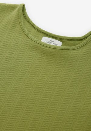 Haut de maternité en tissu vert atténué, avec une texture côtelée et un col rond. L'étiquette indique "NEXT maternité."