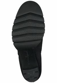 Suela de zapato de goma negra con una superficie texturizada, que presenta ranuras horizontales para tracción y un diseño de puntera lisa y redondeada.