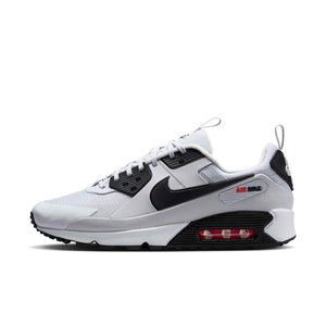 Baskets Nike Air Max blanches et noires avec un coussin d'air rouge visible dans la semelle, logo Swoosh noir, et languettes de tirage sur la languette et le talon.