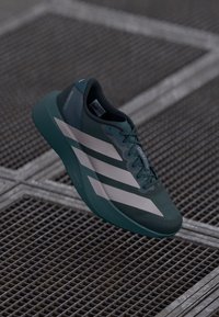 Baskets de sport teal en tissu en mesh, avec trois rayures blanches sur le côté, bout arrondi et semelle rembourrée.