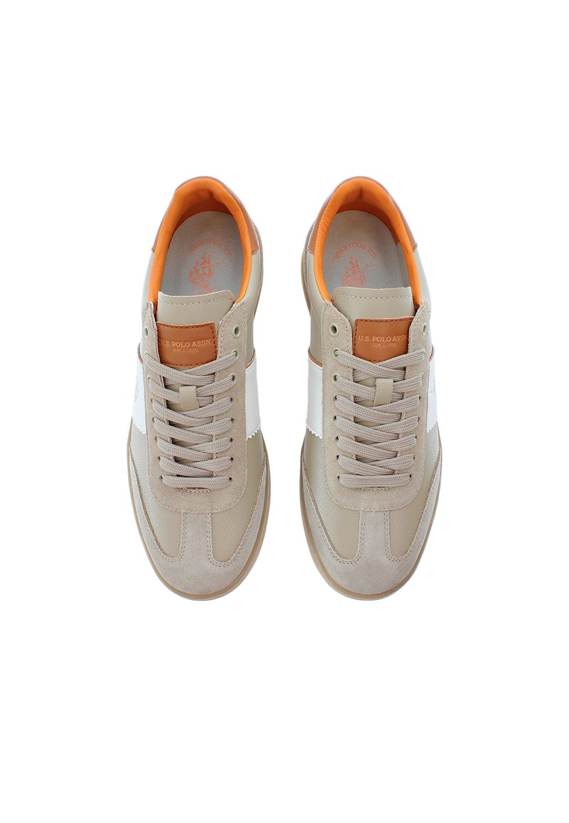 Zapatillas beige con parte superior de cuero suave, panel lateral blanco, interior naranja y cordones grises. Presenta un emblema de cuero marrón en la lengüeta.