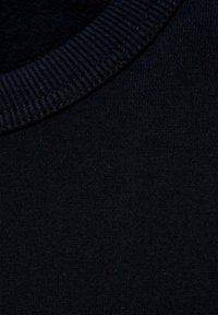 Čierna bavlnená tkanina s rebrovaným golierom typu crewneck. Hladký povrch s konzistentnou väzbou a bez viditeľných vzorov alebo akcentov.