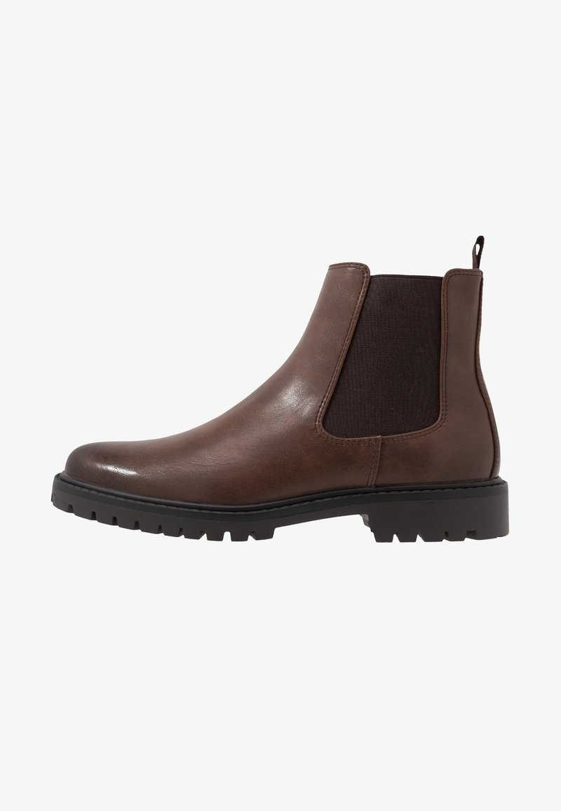 Bottine Chelsea en cuir marron avec panneau latéral élastique noir, languette à l'arrière et semelle épaisse en caoutchouc noir à crampons.