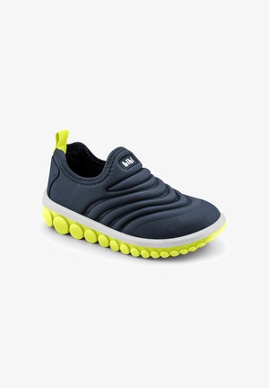 Granatowy but typu slip-on z wyściełaną cholewką, białą środkową częścią podeszwy oraz jaskrawo żółtymi, zaokrąglonymi uchwytami na podeszwie i pętelką z tyłu buta.