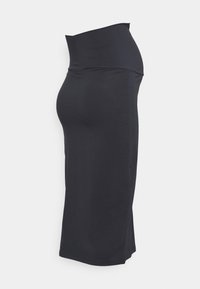 Černá sukně po kolena vyrobená z elastického materiálu s vysokým pasem, s hladkou strukturou a bočními rozparky pro snadný pohyb.