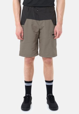Shorts pour hommes bicolores noirs et gris, longueur genou, avec poches, portés avec des chaussettes noires à rayures blanches et des baskets noires.