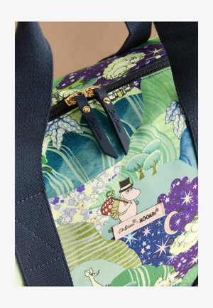 Herbruikbare boodschappentas van geweven stof met flora en Moomin-personages. Blauwe rits met gouden hardware, marineblauwe handvatten en zichtbare merklabel.