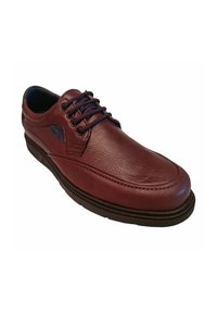 Zapato de cuero burdeos con una textura suave, punta redondeada, diseño de cordones y una suela oscura contrastante. Presenta costuras y acentos sutiles.