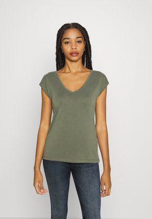 T-shirt à col en V à manches courtes de couleur vert olive, fabriqué en tissu doux, avec une coupe décontractée et des coutures nettes, associé à un jean en denim foncé.