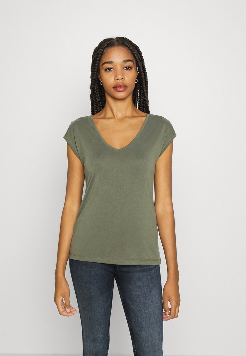 Camiseta de manga corta verde oliva con escote en V, hecha de una tela suave, con un corte relajado y costuras limpias, combinada con vaqueros de mezclilla oscura.
