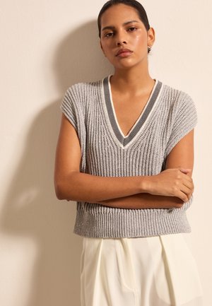 Grauer gestrickter Pullover mit V-Ausschnitt und kurzen Ärmeln, mit gerippter Textur und kontrastierenden Kanten. Kombiniert mit hellen Hosen.