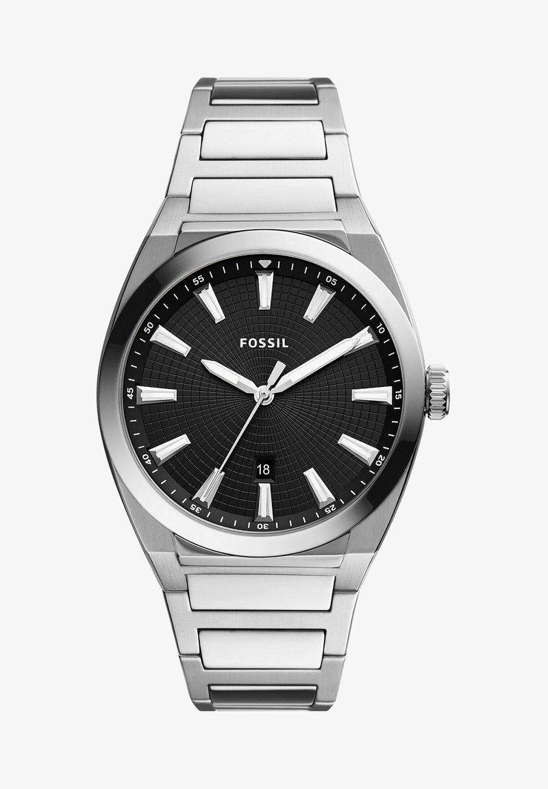 Montre en acier inoxydable argenté avec un cadran noir texturé, des index horaires blancs et un affichage de la date. Elle possède une lunette polie et un bracelet à maillons.
