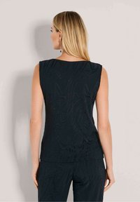 Zwarte mouwloze top met een gestructureerd, golvend patroon. Glad materiaal met een relaxte pasvorm, voorzien van een ronde halslijn en een licht taps toelopende zoom.