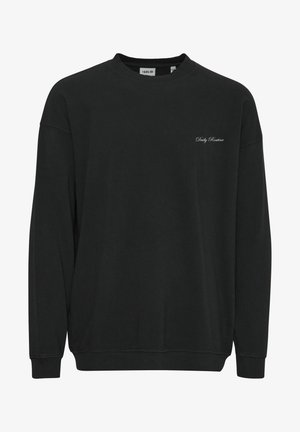 Mustasta puuvillapuserosta, jossa on pyöreä kaula-aukko, pitkät hihat, resorit hihoissa ja hillitty brodeerattu teksti "Päivittäinen Rutiini" rinnassa.