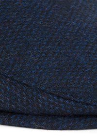 Ciemna wełniana tkanina o teksturowanym, tkanym wzorze. Dominującymi kolorami są głęboki granat oraz subtelne odcienie fioletu. Miękka, ciepła tekstura.