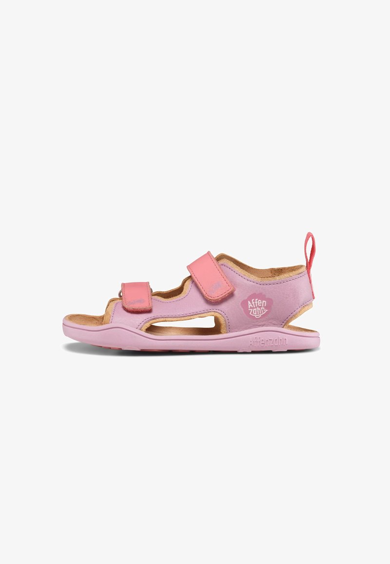 Lichtroze sandalen met een kurken voetbed, voorzien van verstelbare klittenbandbandjes, uitsparingen aan de zijkanten en een logo op de hiel. Lichtgewicht ontwerp.