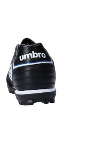 Crni nogometni kopački s teksturiranim sintetičkim gornjim dijelom, koji sadrži istaknuti bijeli "umbro" logo, plave naglaske i gumeni potplat s čavlima.
