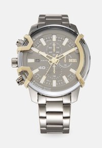 Orologio in acciaio inossidabile con finitura argento, quadrante grigio, dettagli dorati, funzioni cronografiche e bracciale in metallo spazzolato. Diametro della cassa di 40 mm.
