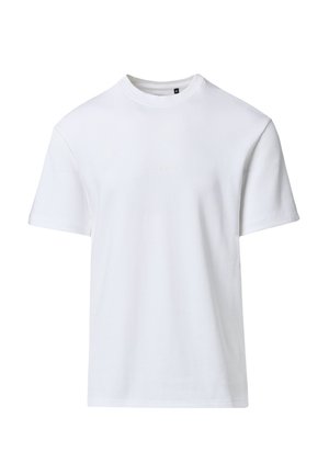 Prosty biały t-shirt z krótkim rękawem i okrągłym dekoltem, z subtelnym tłoczonym napisem na środku klatki piersiowej oraz czarną metką z rozmiarem wewnątrz kołnierzyka.