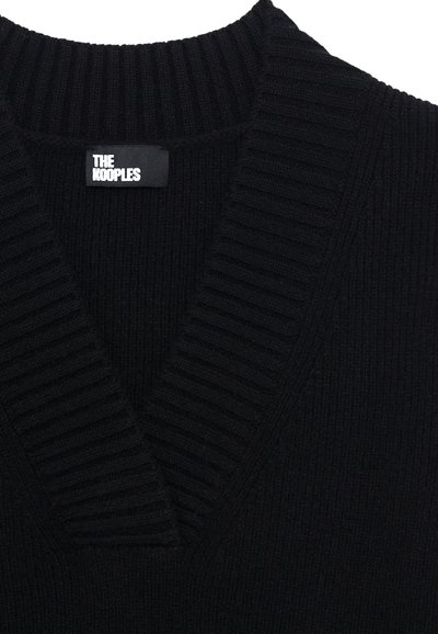 Zwarte gebreide trui met een diepe V-hals, een geribbelde textuur en een label met de tekst "THE KOOPLES" op de hals.