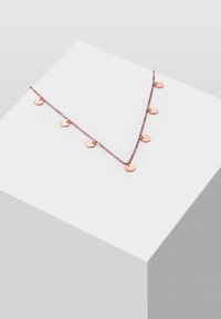 Rosaguld halskæde med en delikat kæde og syv små cirkulære vedhæng, arrangeret i en V-form. Glat overflade og skinnende finish.