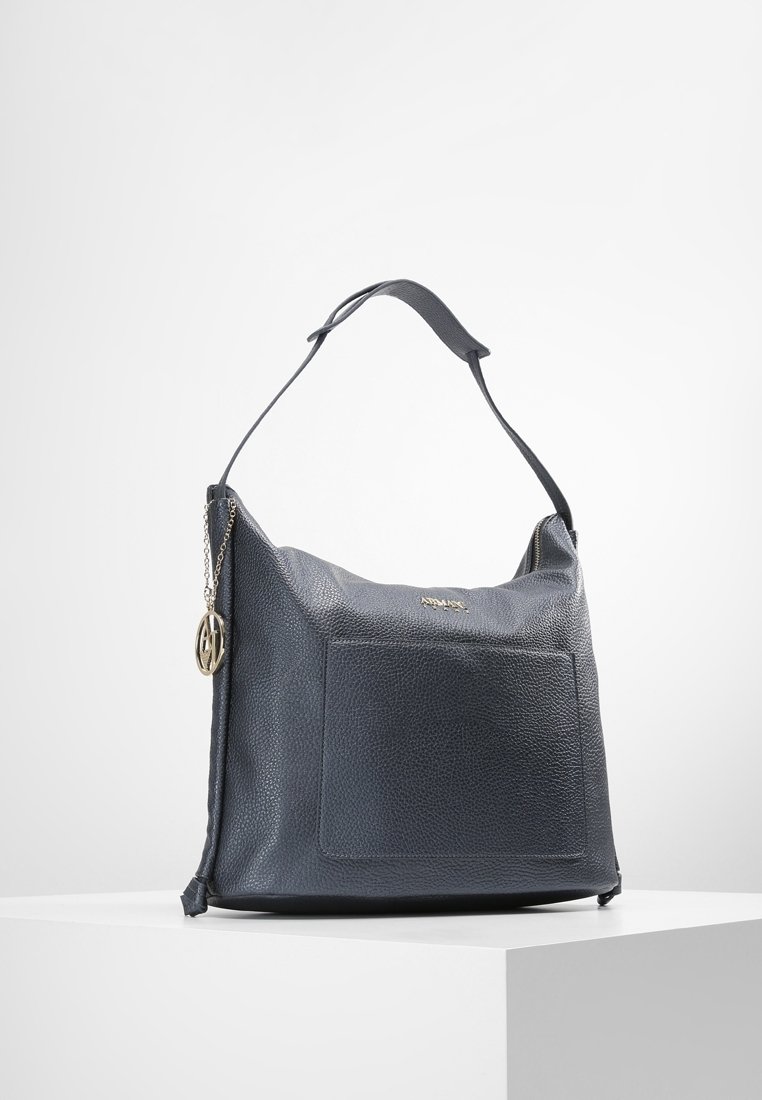 Navy leather bag with a textured surface, a flat front pocket, and a shoulder strap. Features a small chain with a logo accent.