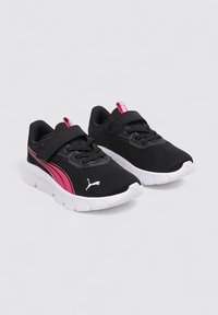 Chaussures de sport noires avec dessus en maille, accents roses, col rembourré et sangle Velcro. Semelle en caoutchouc blanc avec semelle texturée pour l'adhérence.